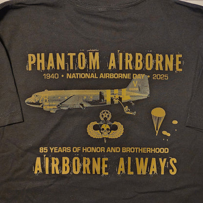 Black t-shirt with gold text and graphics on a wooden surface
