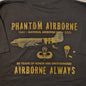 Black t-shirt with gold text and graphics on a wooden surface