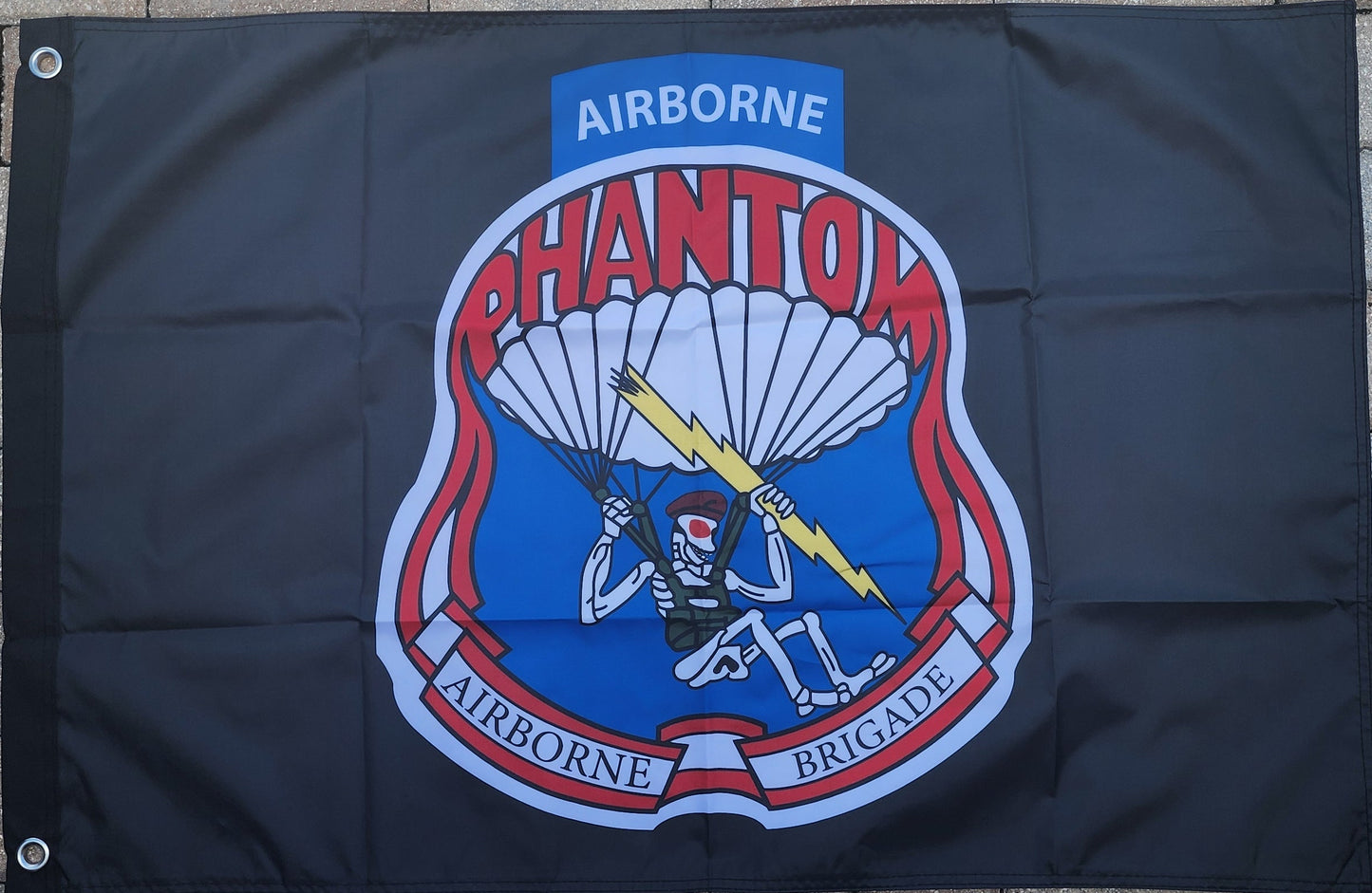 Flag with 'Airborne Phantom Airborne Brigade' emblem on a dark background