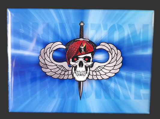 Pin with skull and crossed swords design on a blue background, placed on a textured black surface.