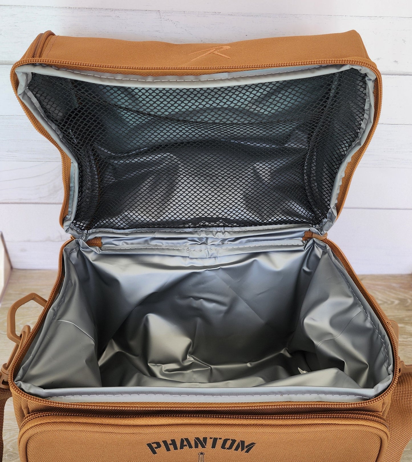 Brown backpack with 'Phantom' branding on a wooden surface.