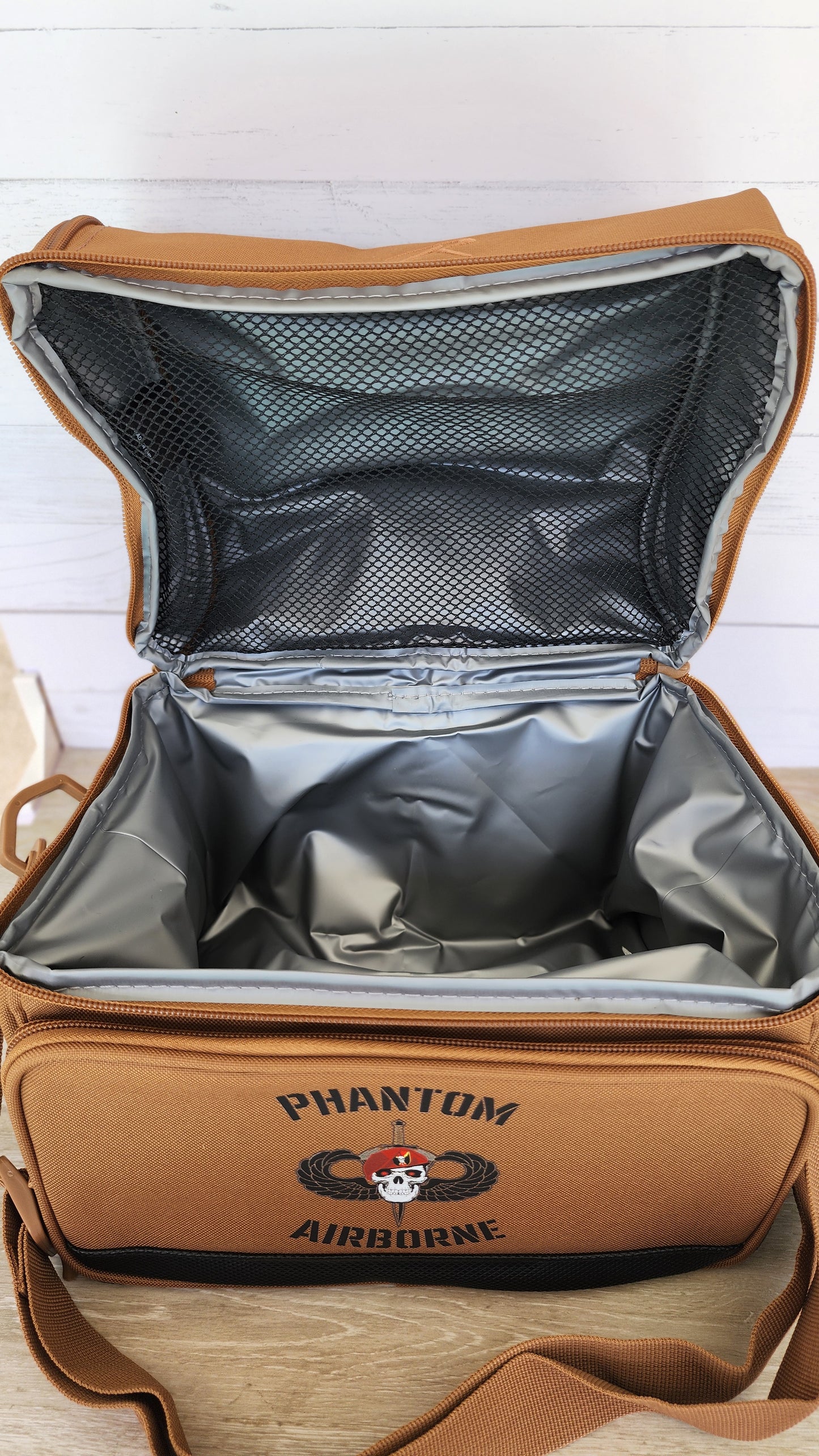 Open tan bag with a visible brand logo on a white wooden surface