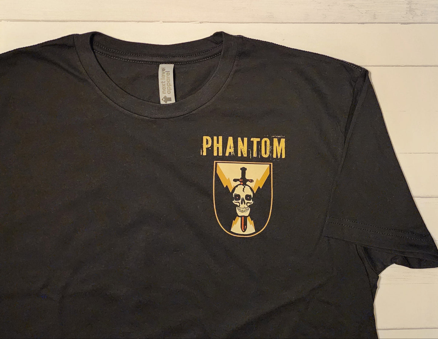 Black t-shirt with 'Phantom' logo on a wooden background
